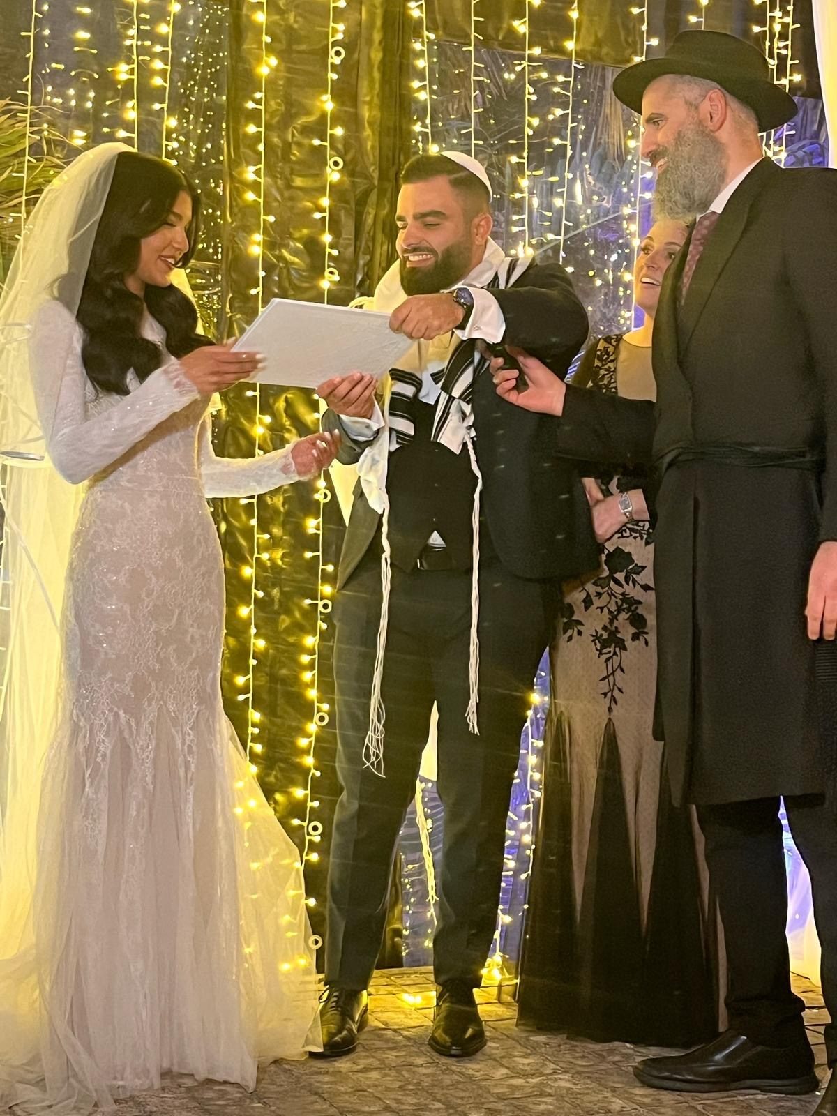 החתן מוסר לכלה את הכתובה מתחת לחופה