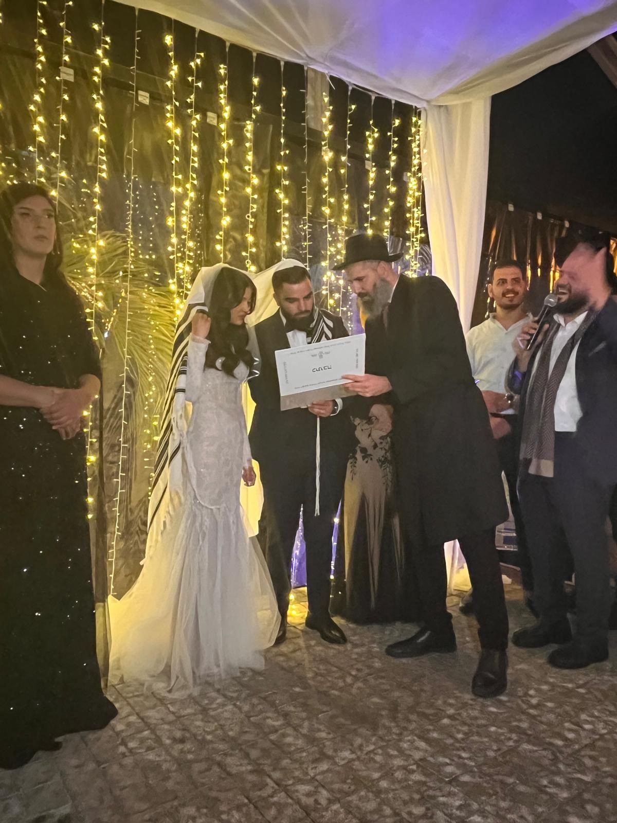 הרב מאור מאיר אוחנה קורא את הכתובה מתחת לחופה