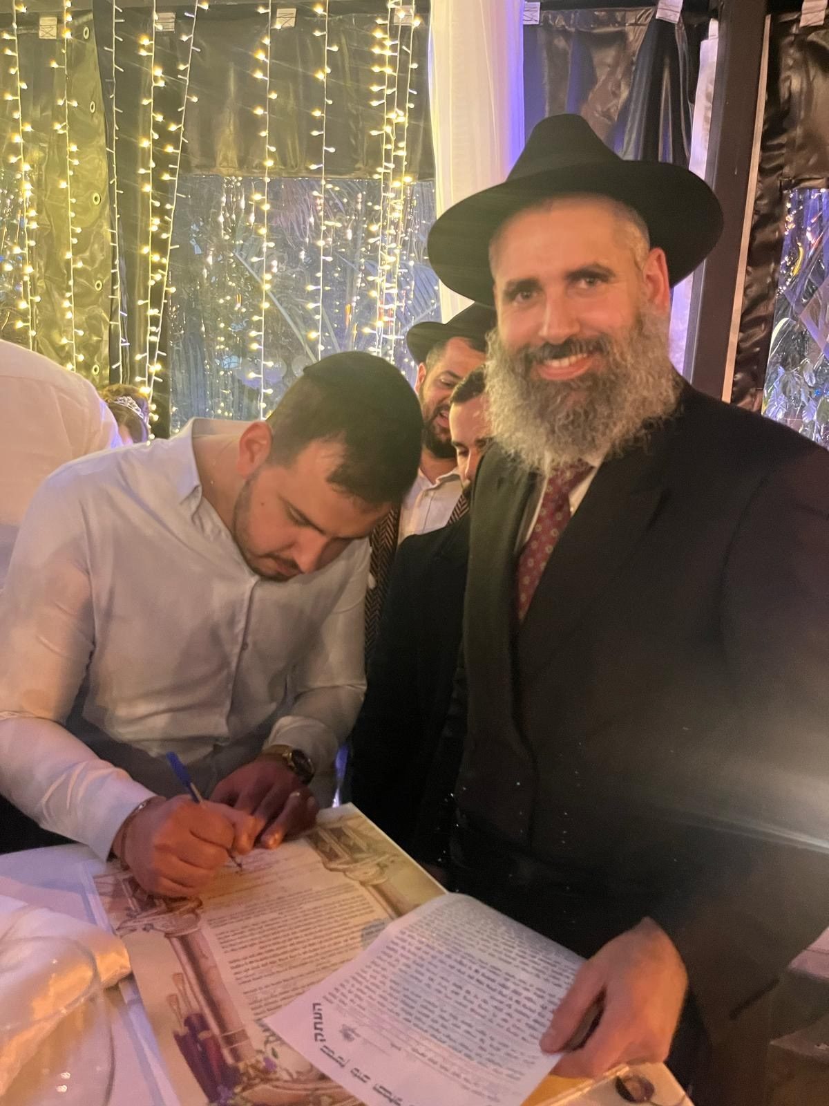 הרב מאור מאיר אוחנה ליד חתן שחותם על הכתובה